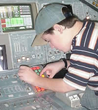 Student on the Shuttle Flight Deck entering commands into the Shuttle's computer.