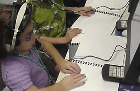 Students in Mission Control reading braille scripts.