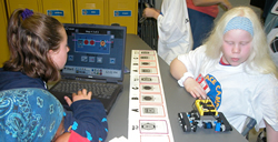 students programming a robot in the robotics lab.
